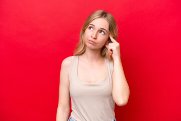 Young English woman isolated on red background making the gesture of madness putting finger on the head