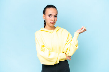 Young Arab woman isolated on blue background having doubts