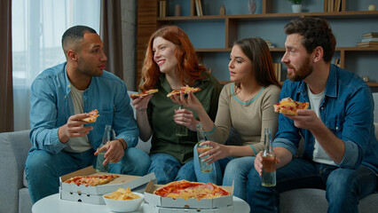 Group of friends colleagues eat pizza talk happy diverse women and men drink beer celebrate event party guys and girls meeting in living room order lunch food delivery at home multiracial friendship