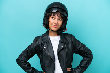 Young Argentinian woman with a motorcycle helmet isolated on blue background thinking an idea while...