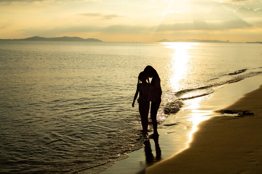 silhouette couple in love on summer beach sunset. Happy romantic couple enjoying and relaxing on the Beach