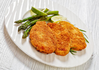 breaded chicken breasts with asparagus and lime