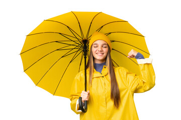 Teenager girl with rainproof coat and umbrella over isolated chroma key background doing strong...