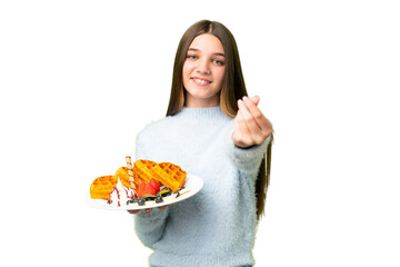 Teenager girl holding waffles over isolated chroma key background making money gesture