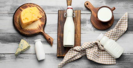 Different dairy products on light wooden background, top view