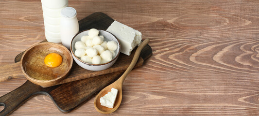 Different dairy products on wooden background with space for text