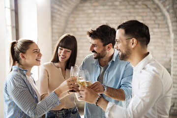 Group of happy business people toasting with wine at office party
