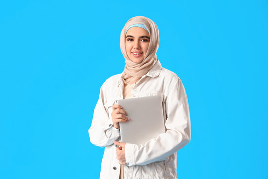 Arabian female programmer with laptop on blue background