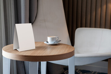 Blank table tent on a wooden table in an office or cafe setting. 3D render illustration