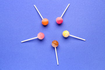 Composition with sweet lollipops on blue background