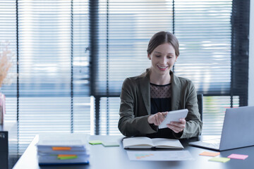 Happy young businesswoman  American siting on the chair cheerful demeanor raise holding coffee cup smiling looking laptop screen.Making opportunities female working successful in the office.