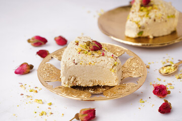 Plates with pieces of tasty Tahini halva on white background
