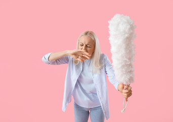 Mature woman with pp-duster on pink background