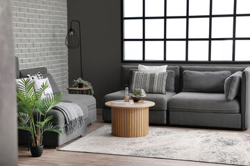 Interior of modern living room with cozy armchairs, sofa and florarium on coffee table