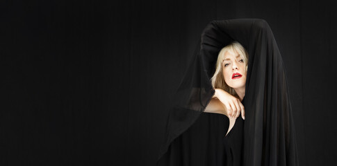 Wide banner portrait of blonde fashion beauty model woman, with red mouth and black fabric, cloth...