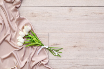 Silk dress with tulips on light wooden floor