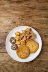 A plate of fried meats with a fried chicken and fried potato.