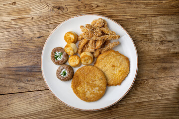 A plate of fried meats with a fried chicken and fried potato.