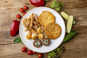 A plate of fried meats with a fried chicken and fried potato.