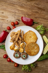A plate of fried meats with a fried chicken and fried potato.