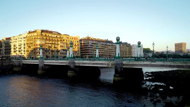 San Sebastian, SPAIN - July 09 2022. View of Kursaal zubia Bridge, in the old city center of the town. Sunset colours. People and cars passing on the bridge. Stabilized static video.