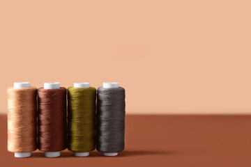 Row of thread spools on color background