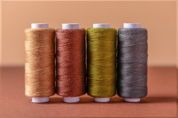 Row of thread spools on color background