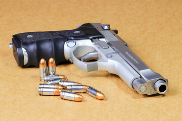 bullet 9mm parabellum and Beretta 92FS, M9 gun on brown paper background.