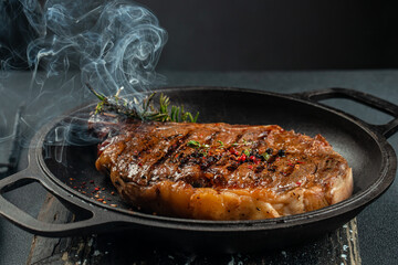 beef grill steak with smoke. The concept of cooking meat, Food recipe background. Close up