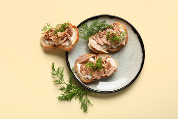 Plate with delicious tuna bruschettas on beige background