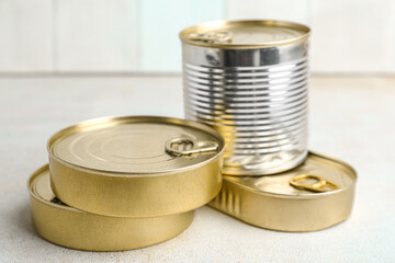 Tin cans with fish on white table