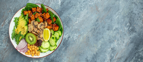 Vegan tofu poke bowl with avocado, chickpeas, cucumber and mushrooms, Healthy asian diet vegan vegetarian salad food. Long banner format. top view