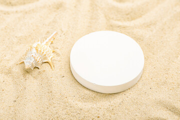 Decorative plaster podium and seashell in sand