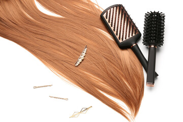 Ginger hair with pins and brushes on white background