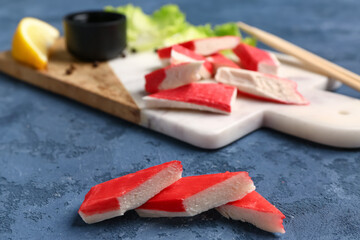 Tasty cut crab sticks on blue background © Pixel-Shot