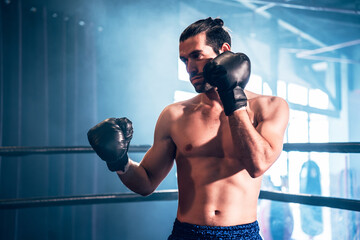 Strong caucasian sportsman wearing boxing gloves for training muay thai at gym, Active male workout...