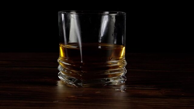 sliding a drink on a bar top -black background (4k - slow motion)[ high quality colors]
