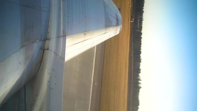 View from aircraft window on wing and runway during plane take off in airport.