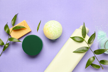 Obraz na płótnie Canvas Bath bomb with accessories and plant branches on lilac background