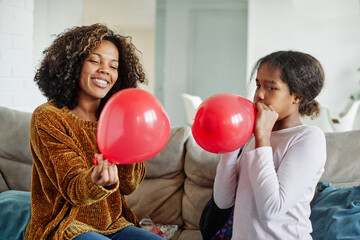 child mother family parent  daughter happy balloon party fun blowing teenage teen black african american celebration birthday blow playing kid together childhood girl mom