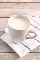 Fototapeta na wymiar Cup of milk on wooden background