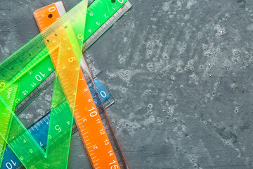 Colorful straight and triangle plastic rulers on grunge background