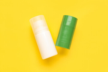 Different deodorant bottles on yellow background