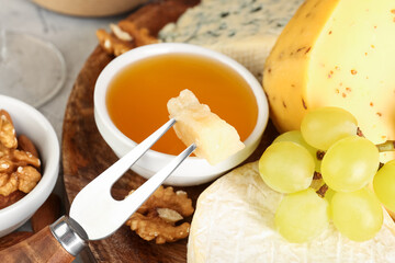 Fork with piece of tasty cheese on table, closeup
