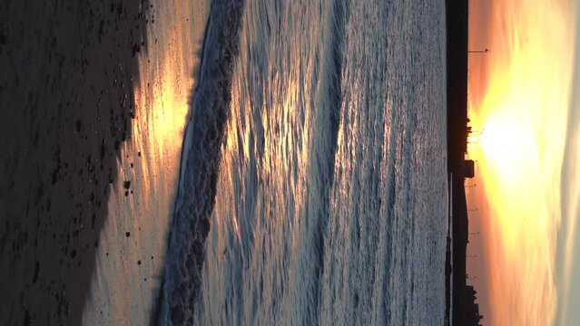 Ocean sandy beach and waterfront in Cadiz Spain in evening during fire sunset.