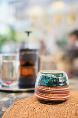 Vertical shot, close-up of cup for tea on a table in a cafe, steam from tea rises above the teapot, selective focus, blurred background. Meeting with friends in a cafe, sustainable social development