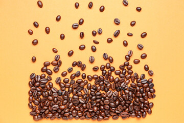Scattered coffee beans on orange background