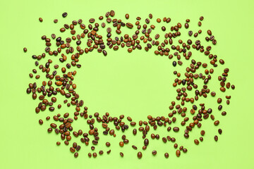Frame made of coffee beans on green background