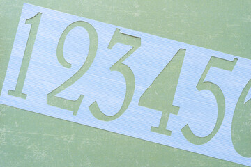 paper stencil with number cutouts on green scrapbook paper