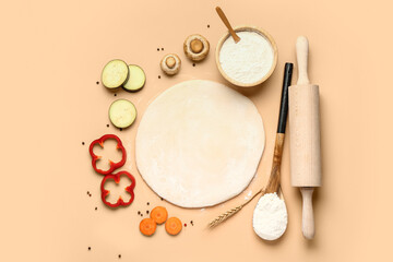 Raw dough and ingredients for preparing vegetable pie on beige background